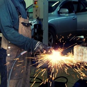 Mechanic-working-on-car-panels-with-a-cutter